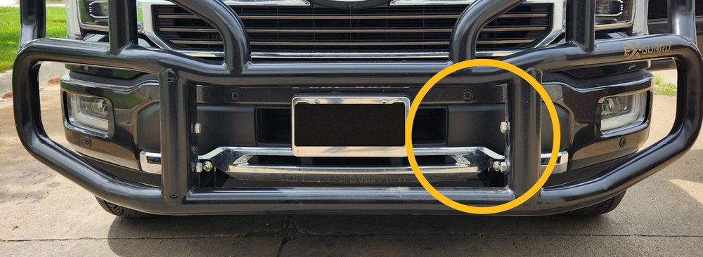 Front of a Ford pickup with an Ex-Guard grille guard installed, the adaptive cruise control radar sensor circled and unobstructed