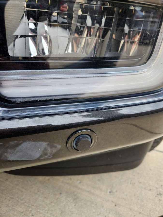Close-up of the same front bumper parking sensor with an Ex-Guard mute applied over it
